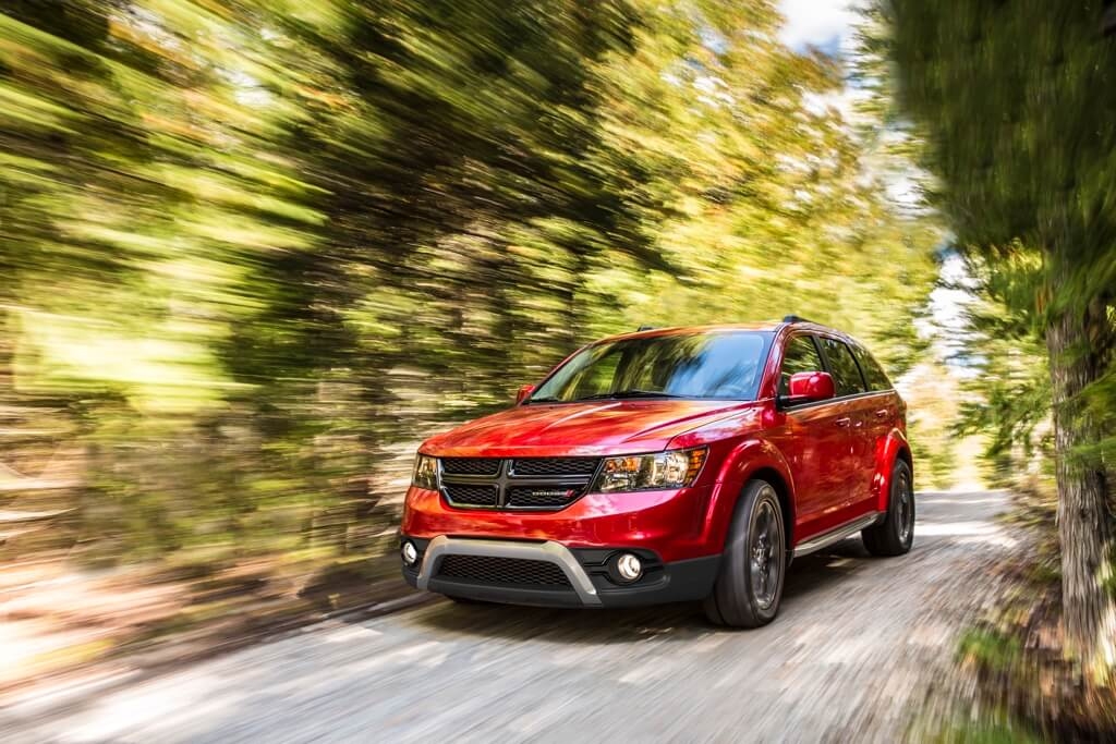 3/4 front view of the 2018 Dodge Journey SUV driving on a nature trail.