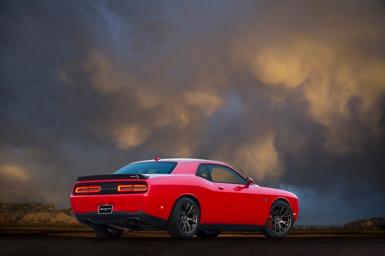 3/4 rear view of the 2017 Dodge Challenger SRT under a cloudy, orange sky.