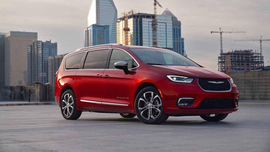 Chrysler Pacifica 2025 rouge version Pinnacle de trois quarts avant, stationné en ville, mettant en avant son style haut de gamme.