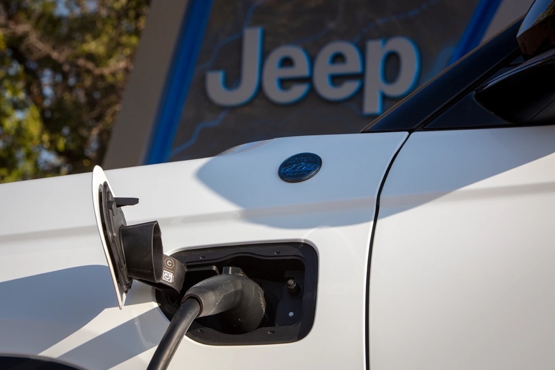 Close-up on the charging port of a Jeep Grand Cherokee 4xe connected to a charging station.
