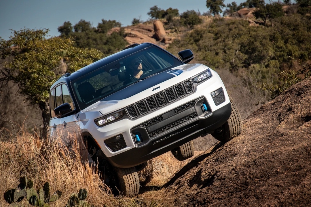 Jeep Grand Cherokee 4xe Trailhawk climbing a steep slope on a off-road trail.