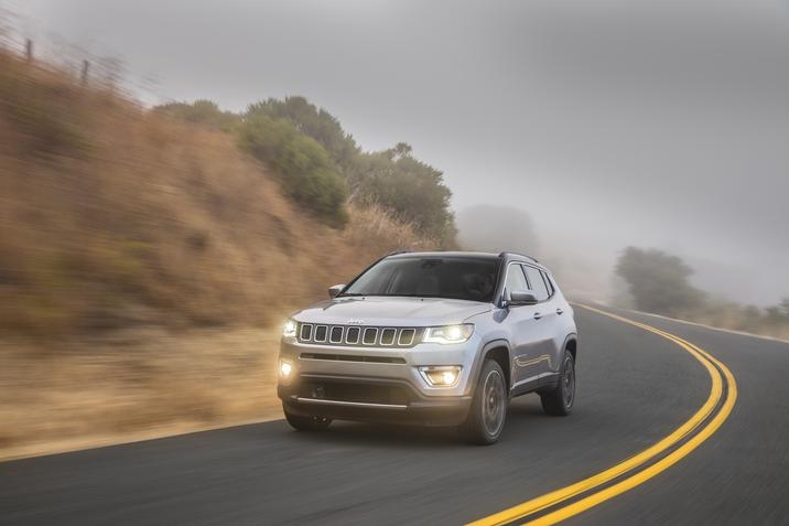 Jeep Compass limited 2020, phares avant allumés, effectuant un virage sur un autoroute