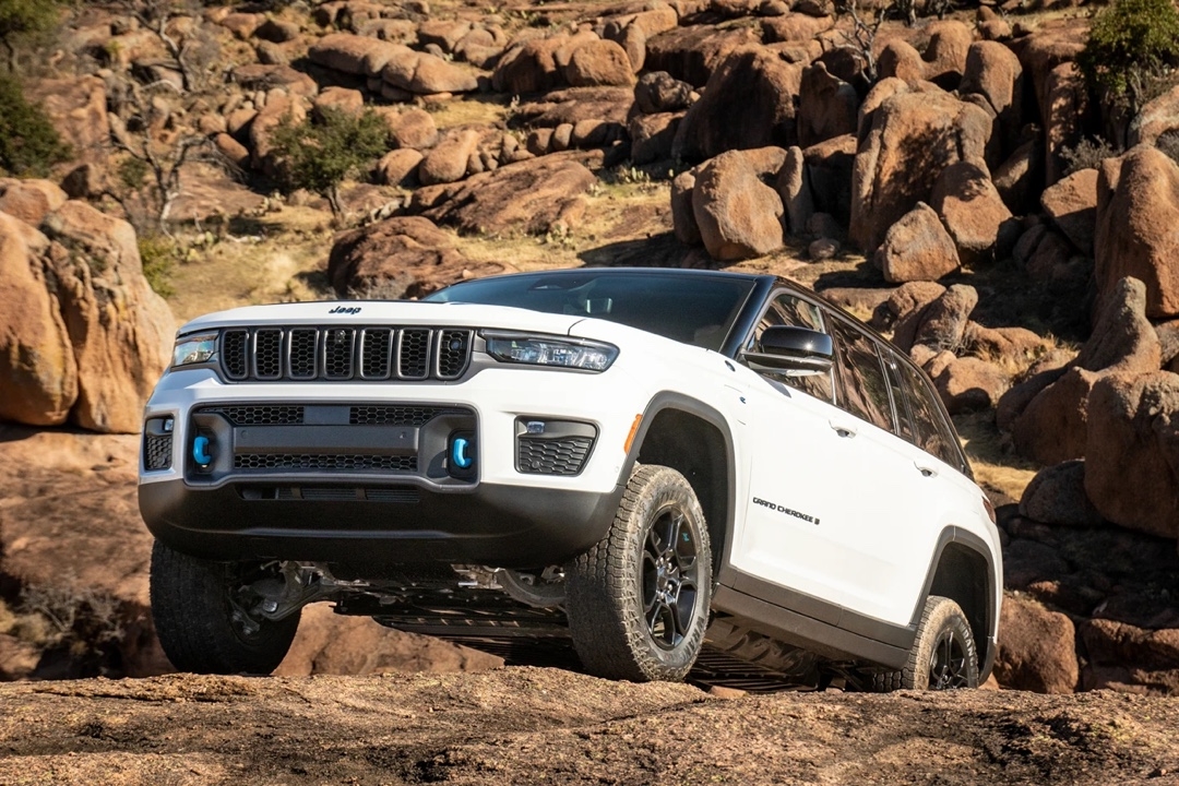 Jeep Grand Cherokee 4xe Trailhawk traversing rocks on an off-road trail.