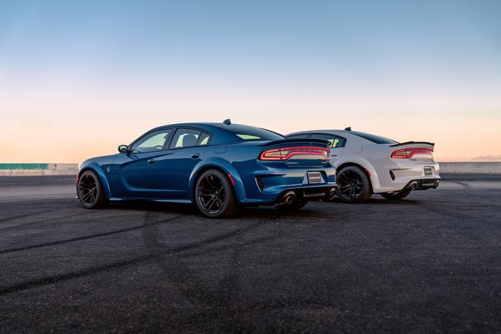 Dodge Charger SRT Hellcat Widebody 2021 bleu côte-à-côte via la Dodge Charger Scat Pack Widebody 2021 blanche garées sur une piste