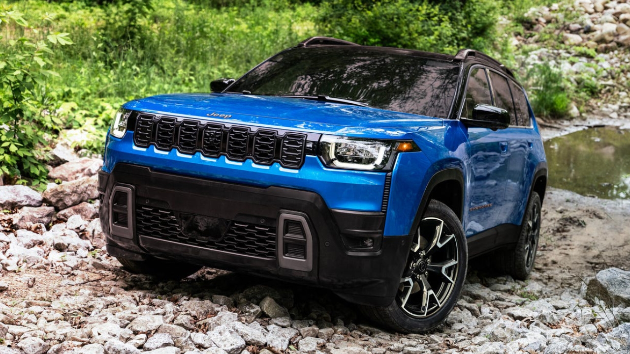 Jeep Cherokee 2026 bleu sur terrain rocailleux, mettant en évidence ses aptitudes hors route et sa garde au sol élevée.