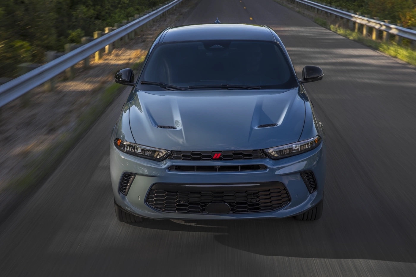 Vue avant du Dodge Hornet 2025 gris sur autoroute avec lignes de capot sport.