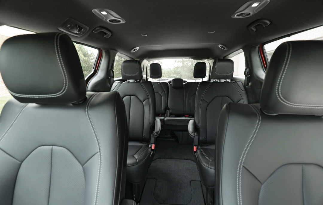 Intérieur du Chrysler Grand Caravan 2025 avec sièges en cuir noir, configuration trois rangées et espace généreux pour familles.